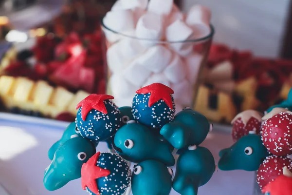 Beautifully decorated multicolored banquet catering with candy bar dessert table with different sweet on kids birthday party with children around — Stock Photo, Image