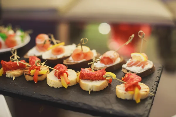 Mesa de banquete de catering bellamente decorada con diferentes alimentos — Foto de Stock