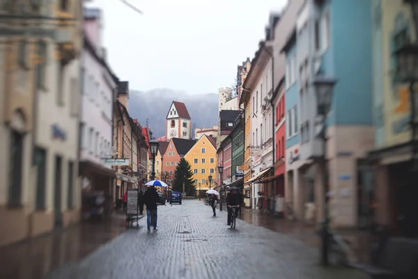 Bela imagem multicolorida vibrante do centro da cidade de rua em Fussen, Bayern, Baviera, Alemanha, com turistas e pessoas andando perto de vitrines e restaurantes, casas em estilo bávaro — Fotografia de Stock