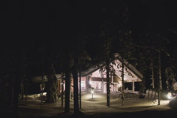 Schöne skandinavisch-finnisch-schwedisch-norwegische Holzhütte in der Nähe der Pisten in einem Skigebiet in der Nacht — Stockfoto