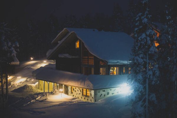Beautiful scandinavian Finnish swedish norwegian wooden cottage cabin near slopes on a ski resort in the night time