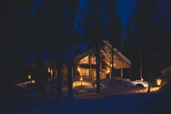 夜の時間でスキー場の斜面に近い美しい北欧のフィンランド スウェーデンのノルウェー木造コテージ キャビン — ストック写真