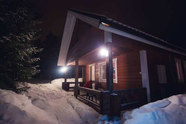 Beautiful scandinavian Finnish swedish norwegian wooden cottage cabin near slopes on a ski resort in the night time