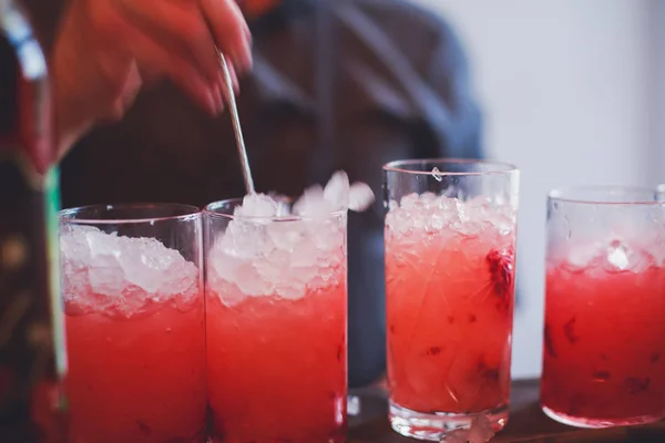 Hermosa línea de fila de cócteles de alcohol de diferentes colores en una fiesta, martini, vodka y otros en la mesa de ramo de catering decorado en el evento al aire libre, imagen con hermoso bokeh —  Fotos de Stock