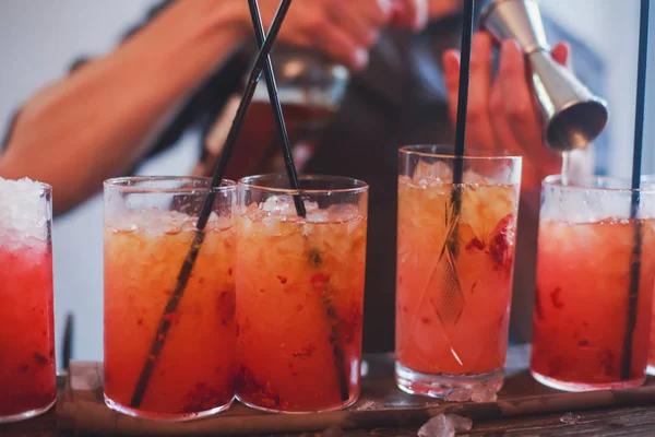 Hermosa línea de fila de cócteles de alcohol de diferentes colores en una fiesta, martini, vodka y otros en la mesa de ramo de catering decorado en el evento al aire libre, imagen con hermoso bokeh —  Fotos de Stock