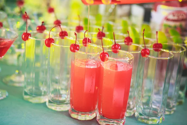 Bella fila di cocktail alcolici colorati diversi su una festa, martini, vodka e altri su tavolo decorato bouquet catering su evento all'aperto, immagine con bel bokeh — Foto Stock