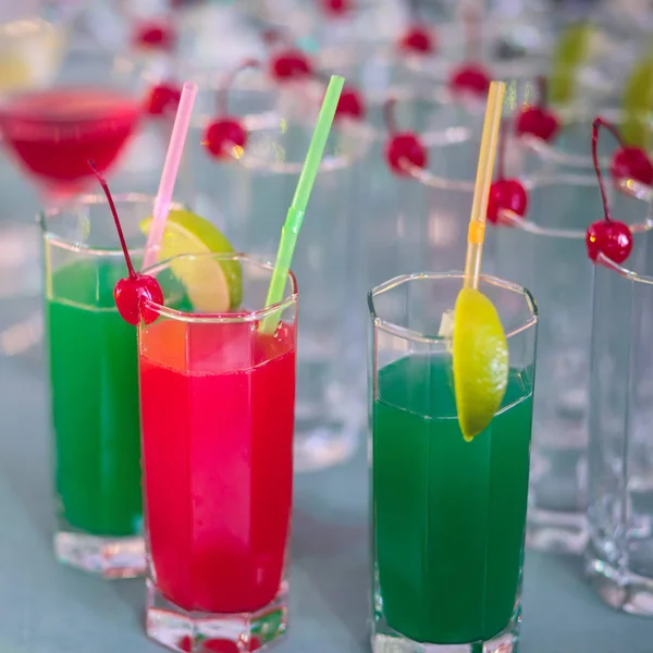 Bella fila di cocktail alcolici colorati diversi su una festa, martini, vodka e altri su tavolo decorato bouquet catering su evento all'aperto, immagine con bel bokeh — Foto Stock