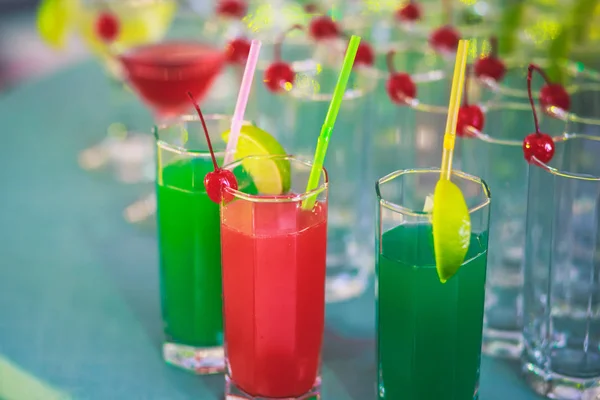 Bella fila di cocktail alcolici colorati diversi su una festa, martini, vodka e altri su tavolo decorato bouquet catering su evento all'aperto, immagine con bel bokeh — Foto Stock