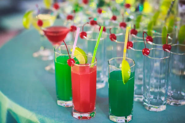 Bella fila di cocktail alcolici colorati diversi su una festa, martini, vodka e altri su tavolo decorato bouquet catering su evento all'aperto, immagine con bel bokeh — Foto Stock