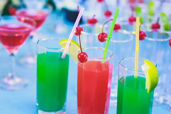 Bella fila di cocktail alcolici colorati diversi su una festa, martini, vodka e altri su tavolo decorato bouquet catering su evento all'aperto, immagine con bel bokeh — Foto Stock