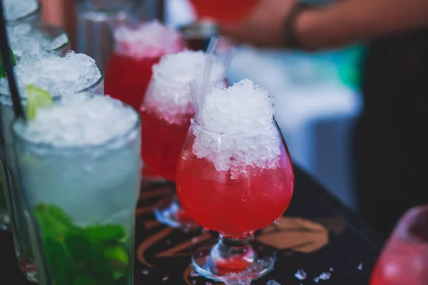 Bella fila di cocktail alcolici colorati diversi su una festa, martini, vodka e altri su tavolo decorato bouquet catering su evento all'aperto, immagine con bel bokeh — Foto Stock