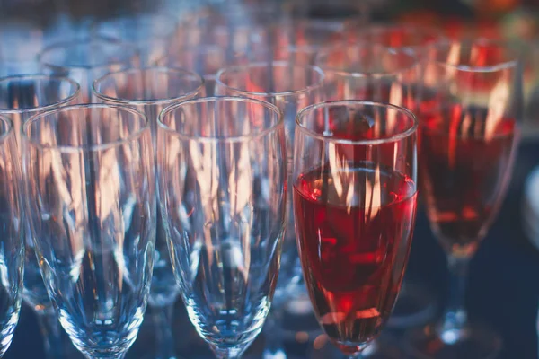 Beautiful row line of different colored alcohol cocktails on a party, martini, vodka,and others on decorated catering bouquet table on open air event, picture with beautiful bokeh — Stock Photo, Image