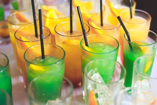 Bella fila di cocktail alcolici colorati diversi su una festa, martini, vodka e altri su tavolo decorato bouquet catering su evento all'aperto, immagine con bel bokeh — Foto Stock