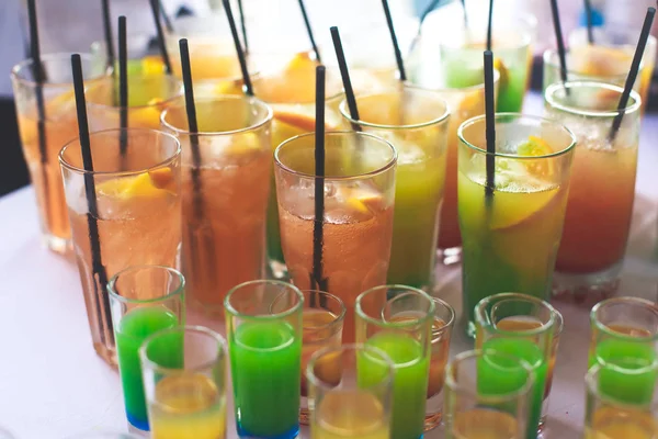 Nádherné řadové různých barevných alkohol koktejly na party, martini, vodku a další na stolování cateringových kytice na open air akce, obrázek s krásným bokeh — Stock fotografie