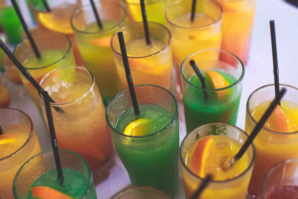 Bella fila di cocktail alcolici colorati diversi su una festa, martini, vodka e altri su tavolo decorato bouquet catering su evento all'aperto, immagine con bel bokeh — Foto Stock