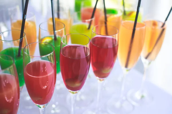 Schöne Reihe von verschiedenen farbigen Alkohol-Cocktails auf einer Party, Martini, Wodka und andere auf dekorierten Catering-Bouquet-Tisch auf Open-Air-Veranstaltung, Bild mit schönen Bokeh — Stockfoto