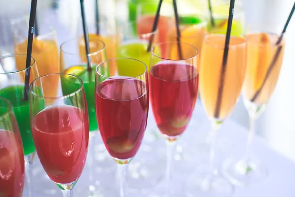 Schöne Reihe von verschiedenen farbigen Alkohol-Cocktails auf einer Party, Martini, Wodka und andere auf dekorierten Catering-Bouquet-Tisch auf Open-Air-Veranstaltung, Bild mit schönen Bokeh — Stockfoto