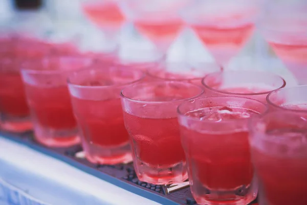 Mooie rijlijn cocktails van de verschillende gekleurde alcohol op een feestje, martini, wodka en anderen op ingerichte horeca boeket tafel op een openlucht evenement, foto met mooie bokeh — Stockfoto