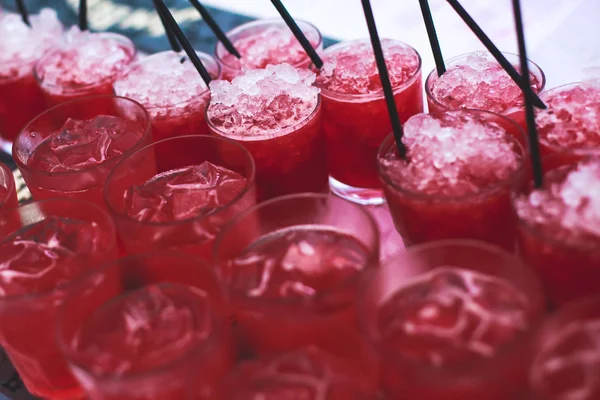 Mooie rijlijn cocktails van de verschillende gekleurde alcohol op een feestje, martini, wodka en anderen op ingerichte horeca boeket tafel op een openlucht evenement, foto met mooie bokeh — Stockfoto