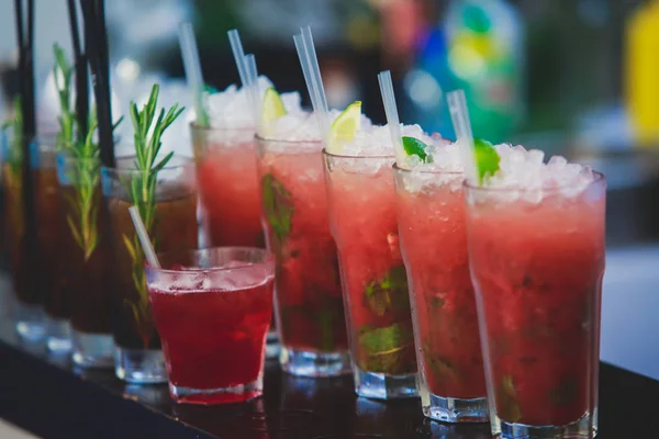 Bella fila di cocktail alcolici colorati diversi su una festa, martini, vodka e altri su tavolo decorato bouquet catering su evento all'aperto, immagine con bel bokeh — Foto Stock