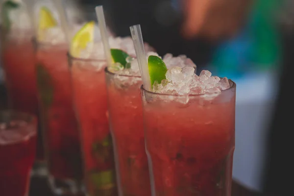 Bella fila di cocktail alcolici colorati diversi su una festa, martini, vodka e altri su tavolo decorato bouquet catering su evento all'aperto, immagine con bel bokeh — Foto Stock