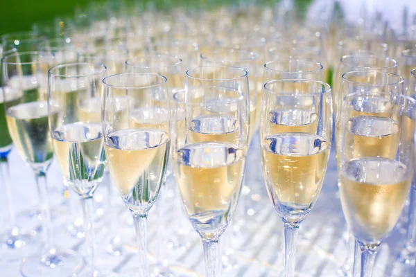 Beautiful row line of different colored alcohol cocktails on a party, martini, vodka,and others on decorated catering bouquet table on open air event, picture with beautiful bokeh — Stock Photo, Image