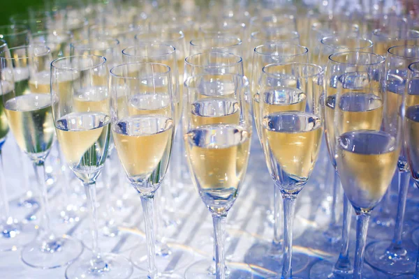 Beautiful row line of different colored alcohol cocktails on a party, martini, vodka,and others on decorated catering bouquet table on open air event, picture with beautiful bokeh — Stock Photo, Image