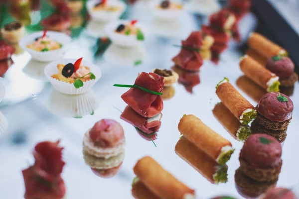 Mesa de banquete de catering lindamente decorada com diferentes lanches e aperitivos de alimentos no evento corporativo de festa de aniversário de Natal ou celebração de casamento — Fotografia de Stock