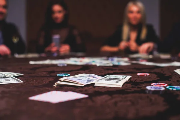 Uma imagem vibrante de close-up de mesa de casino multicolorido com roleta em movimento, com a mão de croupier, e um grupo de pessoas ricas em jogo ricos no fundo — Fotografia de Stock