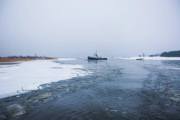 The Icebreaker ship trapped in ice tries to break and leave the bay between the glaciers