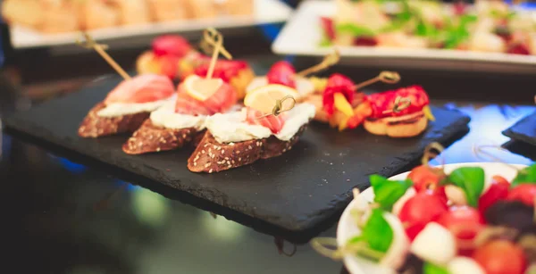 Mesa de banquete de catering bellamente decorada de lujo con caviar negro y rojo y diferentes bocadillos de comida en un evento corporativo de fiesta de cumpleaños o celebración de la boda —  Fotos de Stock
