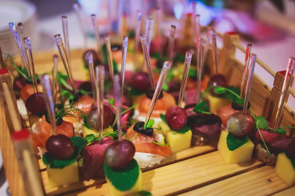 Beautifully decorated catering banquet table with different food snacks and appetizers on corporate christmas birthday party event or wedding celebration — Stock Photo, Image