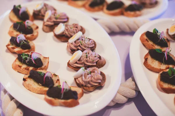 Όμορφα διακοσμημένα catering δεξιώσεων προετοιμασμένοι τραπέζι με διαφορετικά τρόφιμα σνακ και ορεκτικά με σάντουιτς, χαβιάρι, φρέσκα φρούτα σε εταιρική Χριστουγεννιάτικη εκδήλωση πάρτι γενεθλίων ή γαμήλια γιορτή — Φωτογραφία Αρχείου