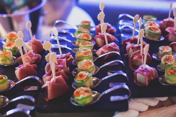 Beautifully decorated catering banquet prepared table with different food snacks and appetizers with sandwich, caviar, fresh fruits on corporate christmas birthday party event or wedding celebration — Stock Photo, Image