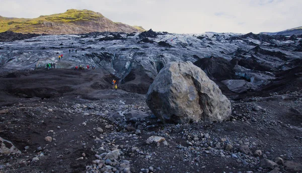 Icelandic Glacier with a group of hikers hiking tourists climbing exploring the famous glacier in Iceland