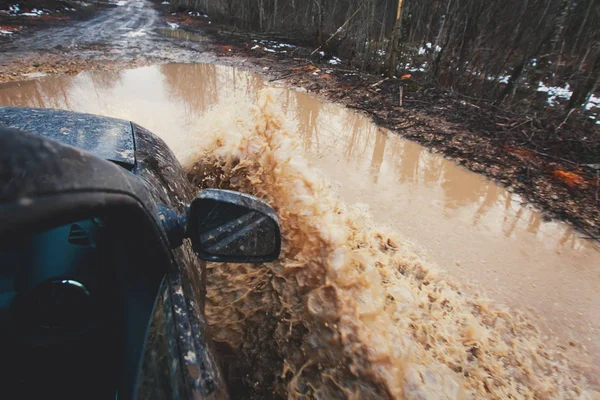 SUV 4wd samochód jeździ przez błotnistej kałuży, torze off-road road, big Splash, podczas konkursu jeeping — Zdjęcie stockowe