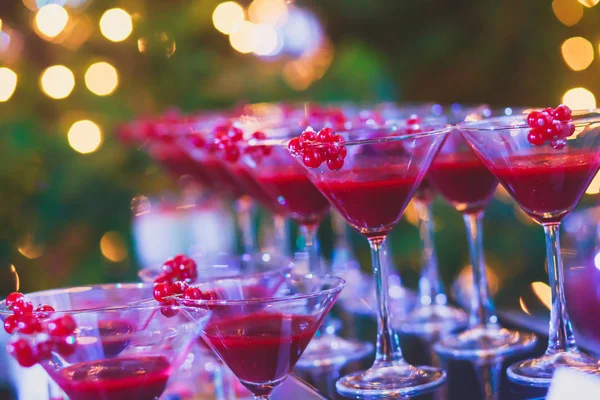 Hermosa línea de cócteles de diferentes colores en una fiesta al aire libre, tequila, martini, vodka y otros en la mesa de ramo de catering decorado en la fiesta al aire libre —  Fotos de Stock