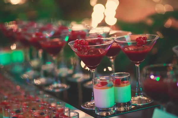 Beautiful line of different coloured cocktails on a open air party, tequila, martini, vodka, and others on decorated catering bouquet table on open air party — Stock Photo, Image