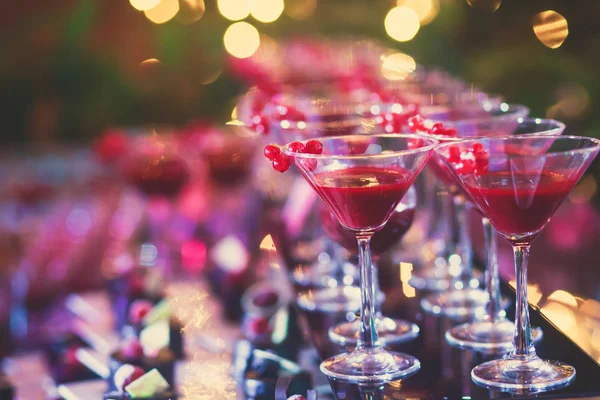 Hermosa línea de cócteles de diferentes colores en una fiesta al aire libre, tequila, martini, vodka y otros en la mesa de ramo de catering decorado en la fiesta al aire libre —  Fotos de Stock