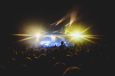 Rock konseri görünümünü büyük konser salonu, kalabalık ve sahne ışıkları, kalabalık konser salonu ile insanlar siluet rock gösterisi performansını sahne ışıkları, show