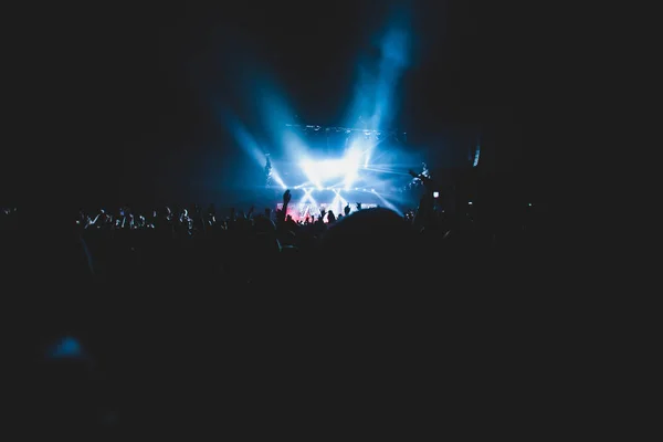 Vista de concierto de rock en gran sala de conciertos, con multitud y luces de escenario, una sala de conciertos llena de gente con luces de escena, espectáculo de rock, con silueta de gente — Foto de Stock