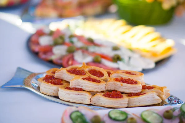 Όμορφα διακοσμημένο τραπέζι γευμάτων με διαφορετικά σνακ τροφίμων και ορεκτικά για την εταιρική χριστουγεννιάτικη εκδήλωση πάρτι γενεθλίων ή γαμήλια γιορτή — Φωτογραφία Αρχείου