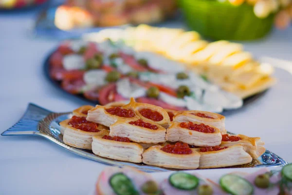 在企业圣诞庆祝会或婚庆活动中，用不同的食品小吃和开胃菜装饰精美的餐桌 — 图库照片