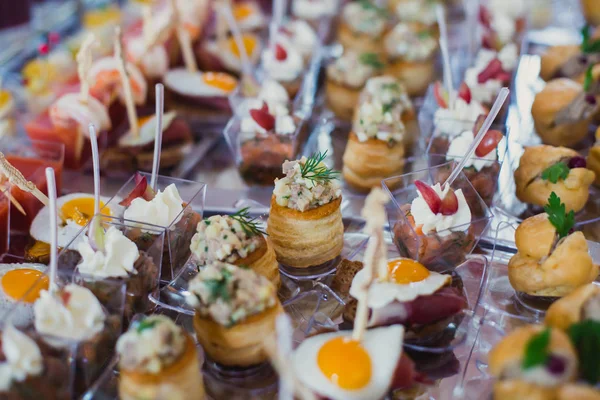 Mesa de banquete de catering lindamente decorada com diferentes lanches e aperitivos de alimentos no evento corporativo de festa de aniversário de Natal ou celebração de casamento — Fotografia de Stock