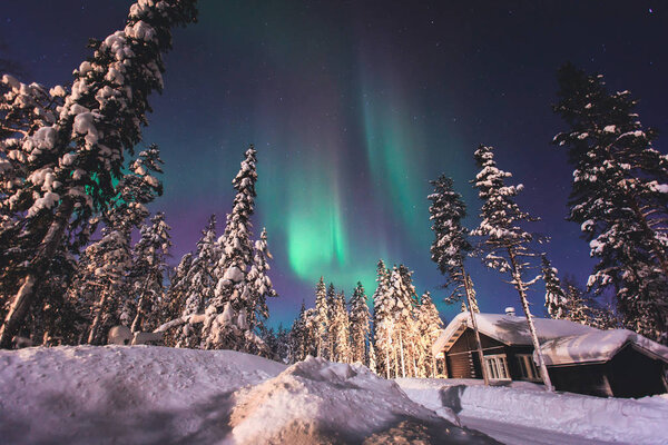 Beautiful picture of massive multicoloured green vibrant Aurora Borealis, Aurora Polaris, also know as Northern Lights in the night sky over winter Lapland, Norway, Scandinavia