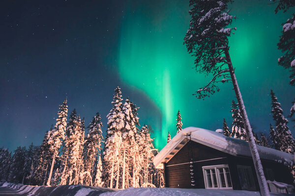 Beautiful picture of massive multicoloured green vibrant Aurora Borealis, Aurora Polaris, also know as Northern Lights in the night sky over winter Lapland, Norway, Scandinavia