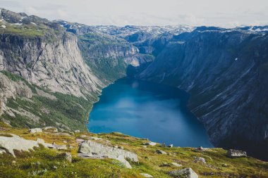Canlı resim ünlü Norveçli yürüyüş yer - yol trolltunga, troller dil, bir turist ile kaya skjegedall ve göl ringedalsvatnet ve dağ panoramik manzara epik görünümü, Norveç