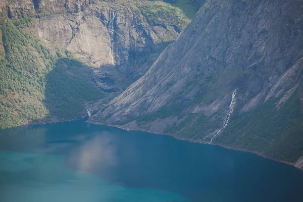 A vibrant picture of famous norwegian hiking place - way to trolltunga, the trolls tongue, rock skjegedall, with a tourist, and lake ringedalsvatnet and mountain panoramic scenery epic view, Norway — Stock Photo, Image