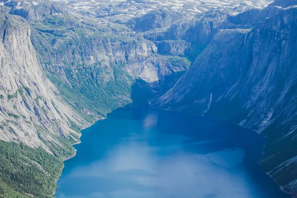 Яркая картинка известного норвежского места для пеших прогулок - путь к троллям, троллям, скалам, скалам, с туристом, а также озеру Рингедалсватнет и горному панорамному пейзажу, Норвегия — стоковое фото