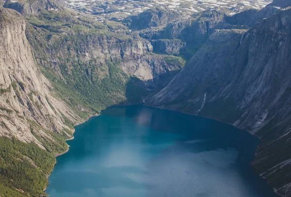 Uma imagem vibrante do famoso local de caminhadas norwegian maneira de trolltunga, a língua trolls, skjegedall rocha, com um turista, e ringedalsvatnet lago e paisagem panorâmica vista épica montanha, Noruega — Fotografia de Stock